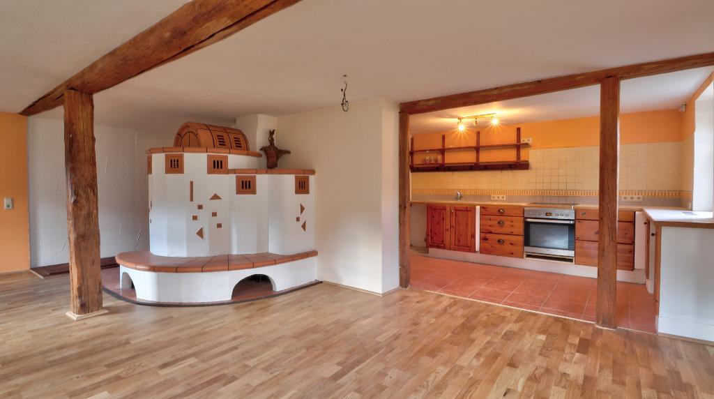 Wohnzimmer mit Kaminofen und offener Küche